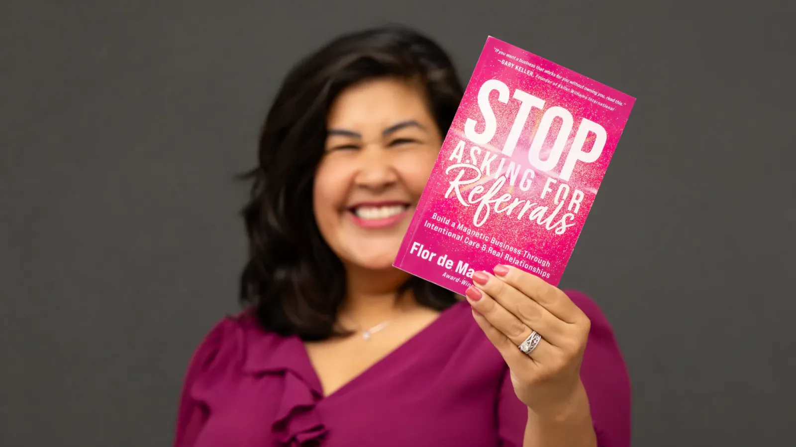 Flor De Maria McNally holding up her book Stop Asking for Referrals