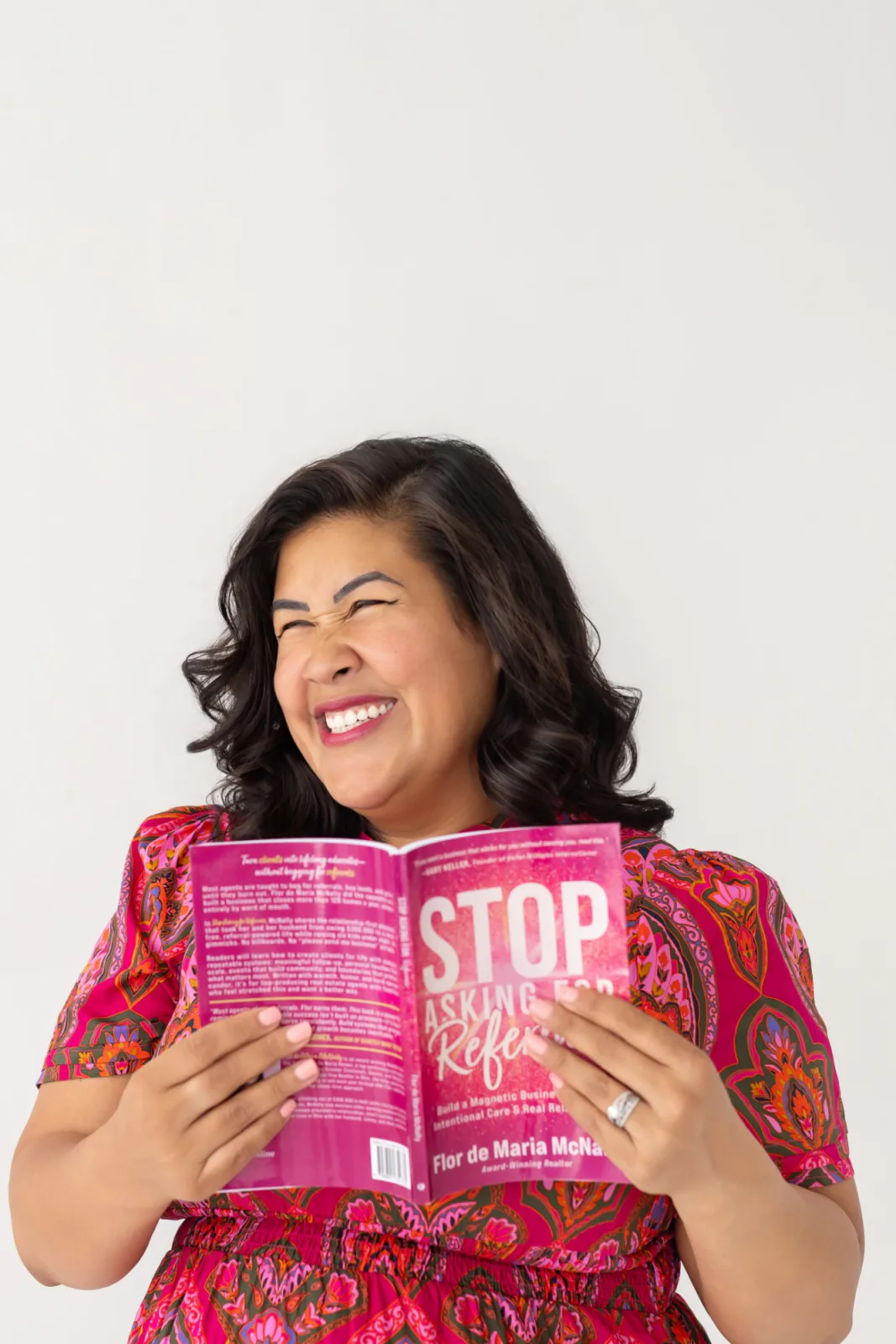 Flor De Maria McNally laughing as she holds her book